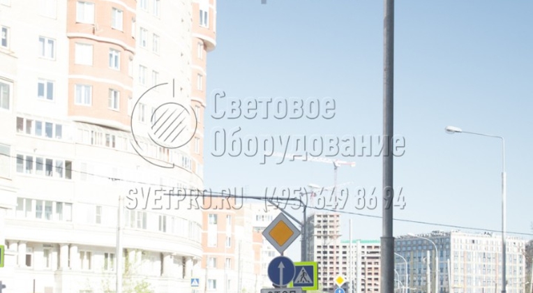 На фото изображена прямостоечная трубчатая опора. Обратите внимание, что в нижней части изделия нет массивного фланца, за который корпус крепится на закладную деталь. Благодаря этому плитка уложена вплотную к поверхности ствола, а опорная площадка не мешает хождению пешеходов.