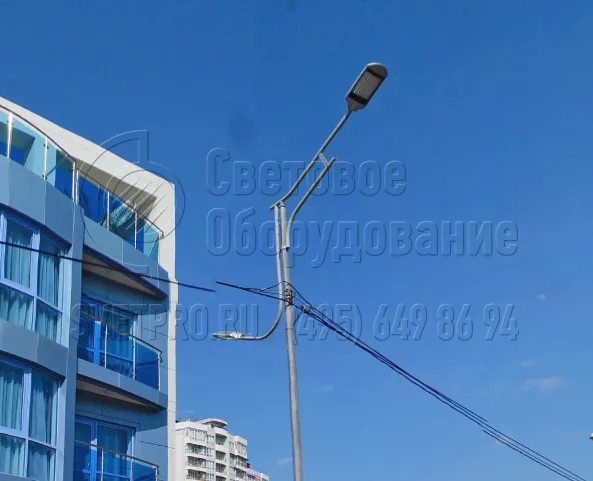 На изображении вы видите кронштейн &laquo;Гранд&raquo; с одним СП для освещения дороги и одним светильником для тротуара. Используется силовая конструкция, электрические кабели подвешены к стволу, а не проложены под землей. Нижняя консоль изделия играет только декоративную роль.