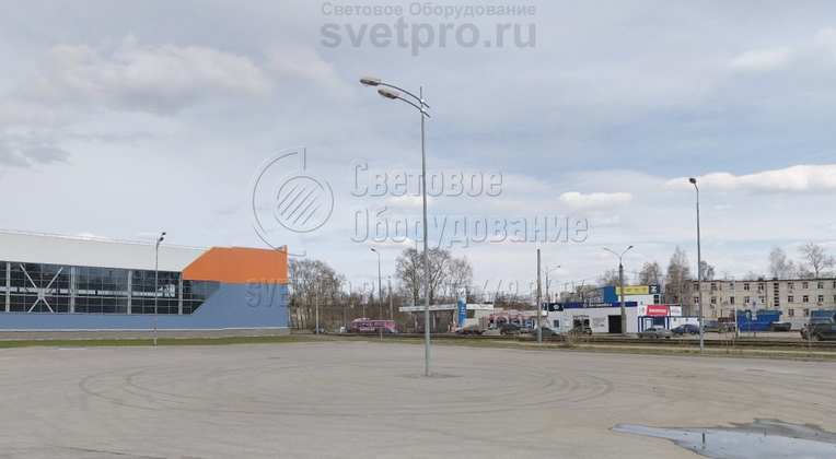 На изображении представлен кронштейн модели «Стрела», к которого можно видеть две консоли под светильники. Так как эта конструкция размещается на парковке для транспорта, инженеры прокладывали кабели в траншеях. Провод к самому светильнику идет внутри кронштейна и не виден снаружи.