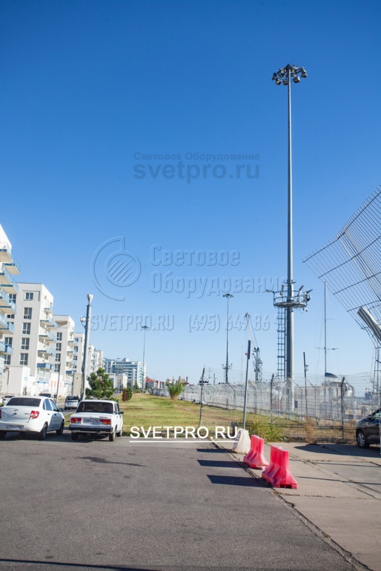 Мачта, которую вы видите на фото, установлена для освещения территории порта. Выбор этой инженерной конструкции обусловлен тем, что ввиду специфики работы объекта транспортной инфраструктуры нельзя останавливать движение специальных средств и грузовых автомобилей во время обслуживания светильников.