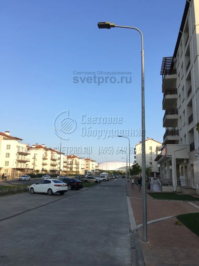 На фото изображена опора, установленная на территории жилого комплекса. Обратите внимание, что между осветительными конструкциями отсутствуют провода. Силовые линии прокладываются под землей, поэтому надежно защищены от обрывов и не портят внешний вид места проживания людей. 