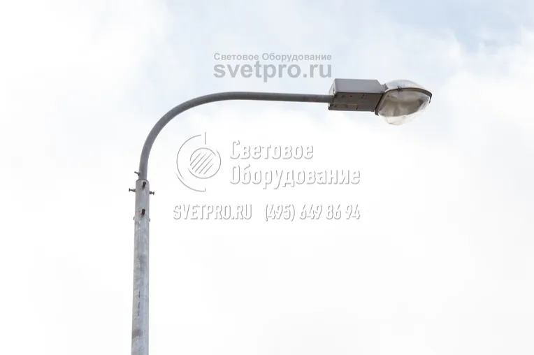 На фото изображен кронштейн для осветительной опоры. На котором установлен световой прибор консольного типа с газоразрядной лампой. Обратите внимание, что провода проложены внутри полой детали, поэтому не висят в воздухе, не портят внешний вид конструкции и защищены от повреждений. 