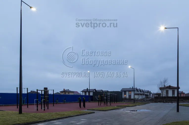 Пример использования опор с футуристичным дизайном для освещения тротуара и спортивной площадки. Для придания конструкциям современного внешнего вида используются кронштейны из двух деталей, соединенных под прямым углом. Установлен светильник с газоразрядной лампой и ПРА внутри. 