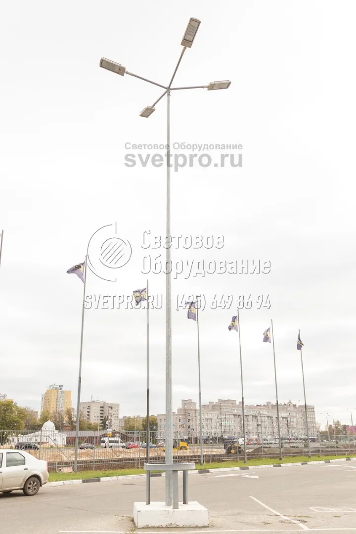 На фото изображена опора, которая установлена на парковке и защищена от повреждений с помощью ограждения. Однако эта мера предосторожности не обязательна, так как фланцевые конструкции можно менять при повреждении, не прибегая к разрушению фундамента и закладной детали. 
