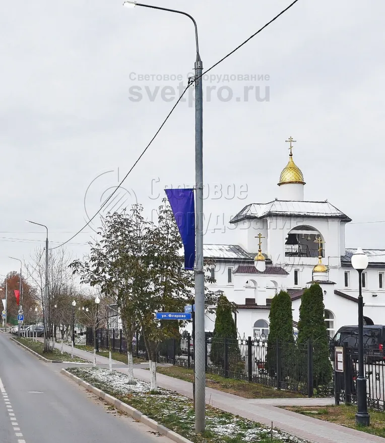 Конструкция на изображении устанавливается в грунт с помощью хвостовика. Поэтому для ее монтажа не нужно покупать закладную деталь фундамента. Кроме того, в нижней части отсутствует большая опорная площадка. Поэтому изделие органично смотрится на газоне, трава подходит вплотную к стволу.