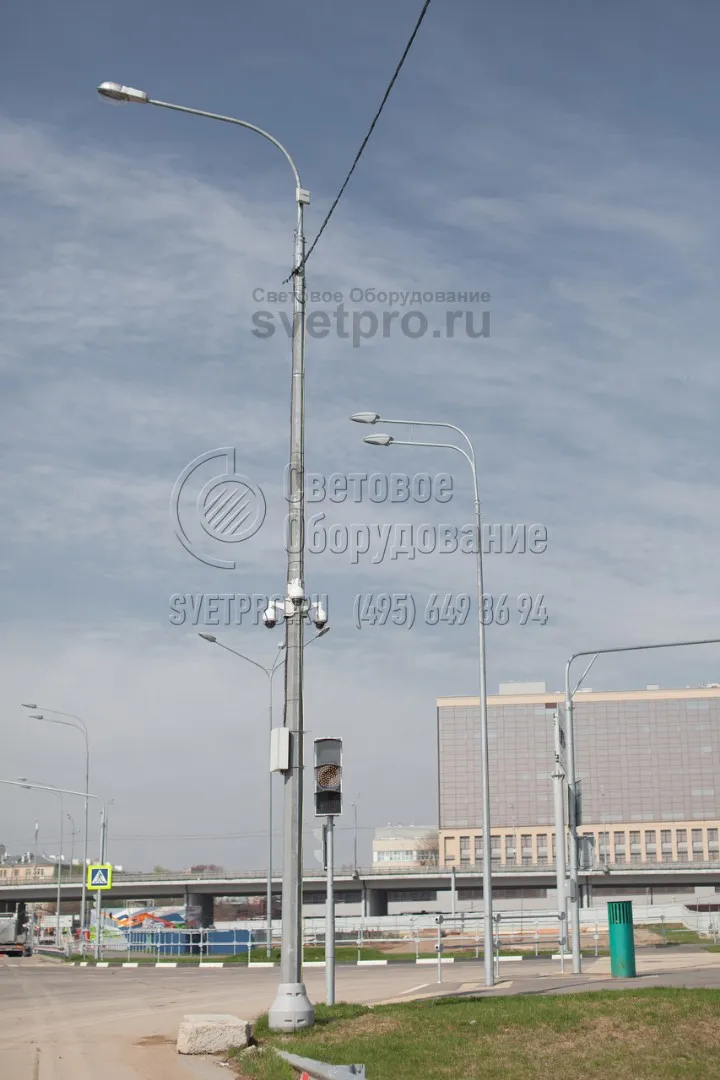 В примере на фото силовая опора используется для установки светильников, камер наружного наблюдения и коробки для коммутационного оборудования. Монтаж ствола произведен на фланец. Опорная площадка с болтами в нижней части декорирована специальной пластиковой накладкой. 