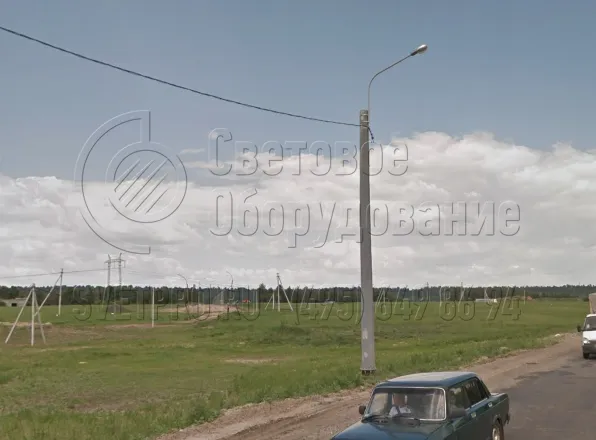 Электрические провода к опоре, которая изображена на фотографии, подведены по воздуху. Строительной компании не пришлось копать траншеи и укладывать в них кабель. Следовательно, при строительстве уменьшается сметная стоимость работ и сокращается время на устройство освещения. 