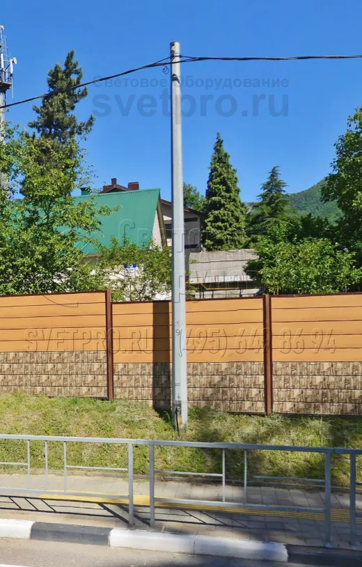 Силовые опоры со стволом в форме многогранника и цинковым покрытием хорошо сочетается с оформлением улицы и в индустриальных, и в жилых районах. В примере на фото изделие гармонирует с ограждением, которое отделяет тротуар для пешеходов от автомобильной дороги. 