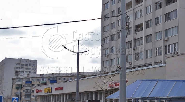 Если опора используется для освещения мест массового проживания людей, вместо утилитарного консольного кронштейна на верхушку ставится декоративный. В примере на фото используется модель с выгнутыми рожками и растяжками до верхушки, светильники установлены на поперечины. 
