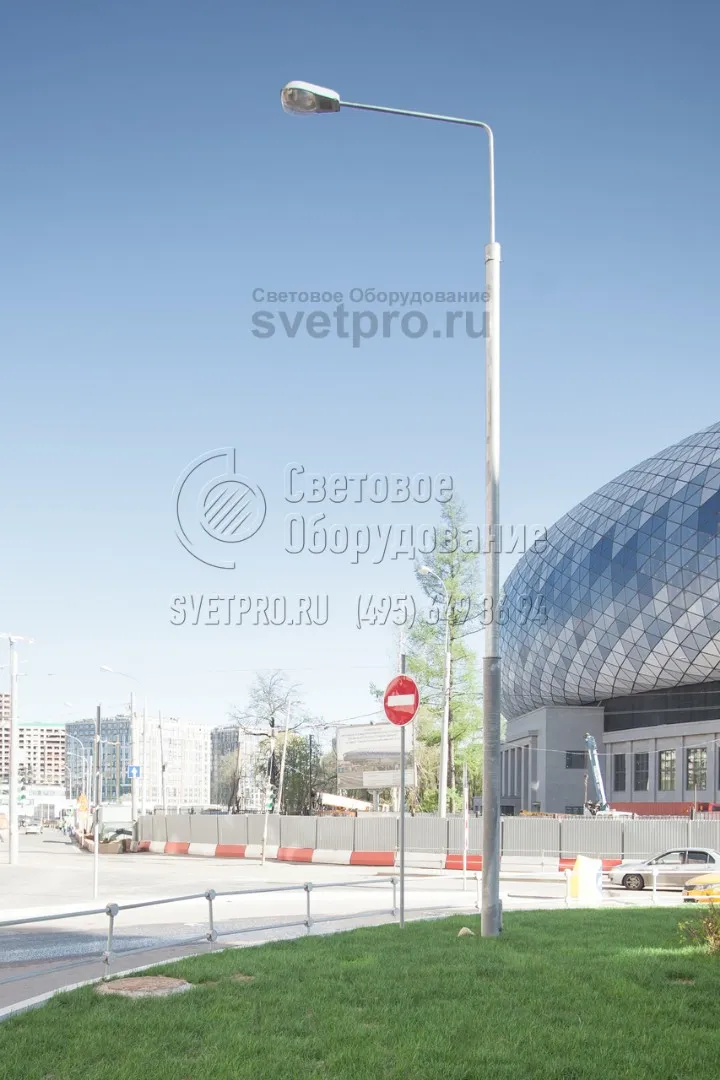 На фото приведет пример установки прямостоечной опоры на газоне. Обратите внимание, что и в этом случае фланец с болтами не портит внешнего вида конструкции. Газонная трава высажена вплотную к стволу. Кабели к этой опоре подведены под землей, поэтому защищены от обрывов из-за ветра. 