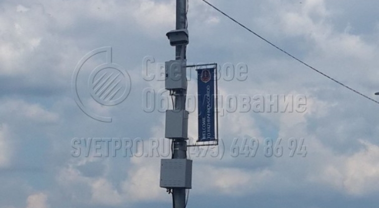 Опора на фотографии способна выдержать вес оборудования в пределах 400 кг, которое размещено на верхней части корпуса. Здесь конструкция используется для установки коммутационного оборудования для систем видеонаблюдения за дорожной обстановкой. 