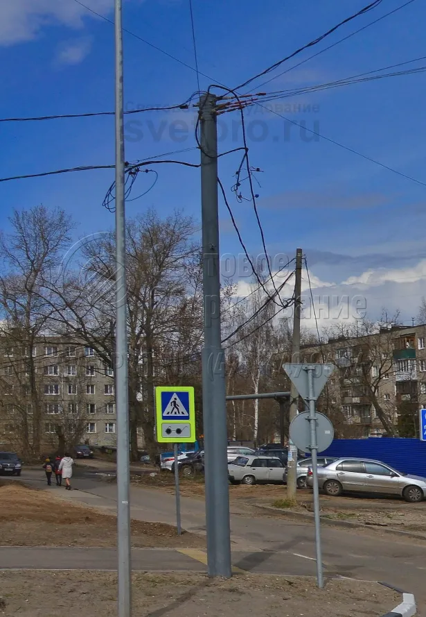 Опора контактной сети на фото установлена в грунте прямостоечным способом. Для этого используется хвостовик. Он погружается в землю в предварительно пробуренный котлован. Для фиксации хвостовик в котловане заливается бетонным раствором. Закладная деталь фундамента не используется. 