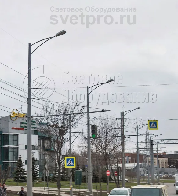 Использование кронштейнов позволяет улучшить внешний вид опор контактной сети, если они используются для строительства системы освещения. В варианте на фотографии на оголовок установлены модели с двумя рожками под один консольный светильник. Так улица выглядит красивее. 