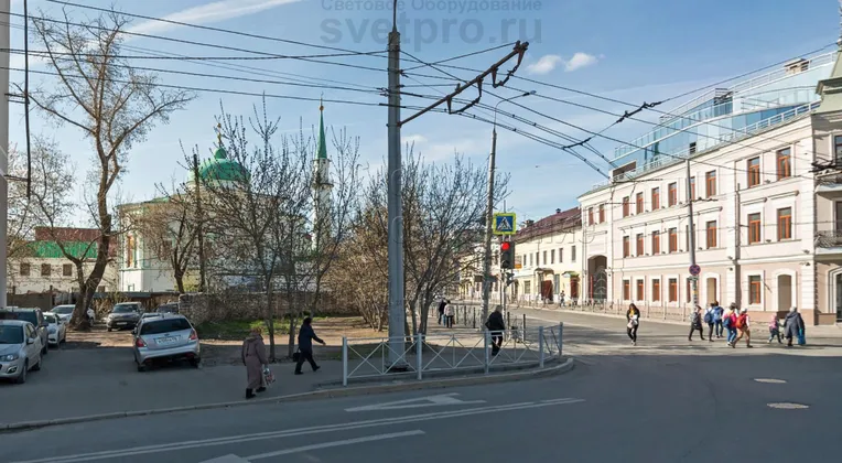 В примере на фото мощная граненая опора освещения используется для удержания горизонтальной консоли с двумя троллейбусными линиями. Кроме того, на нее установлены силовые кабели для подачи питания и светильник уличного освещения. Внизу виден монтажный фланец. 
