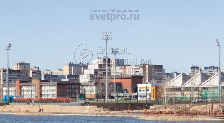 На изображении видны мачты, которые установлены рядом с водоемом и применяются для освещения футбольного поля. Даже в условиях повышенной влажности эти инженерные конструкции могут прослужить до 25 лет и более. Для предотвращения окисления стали используется цинкование.